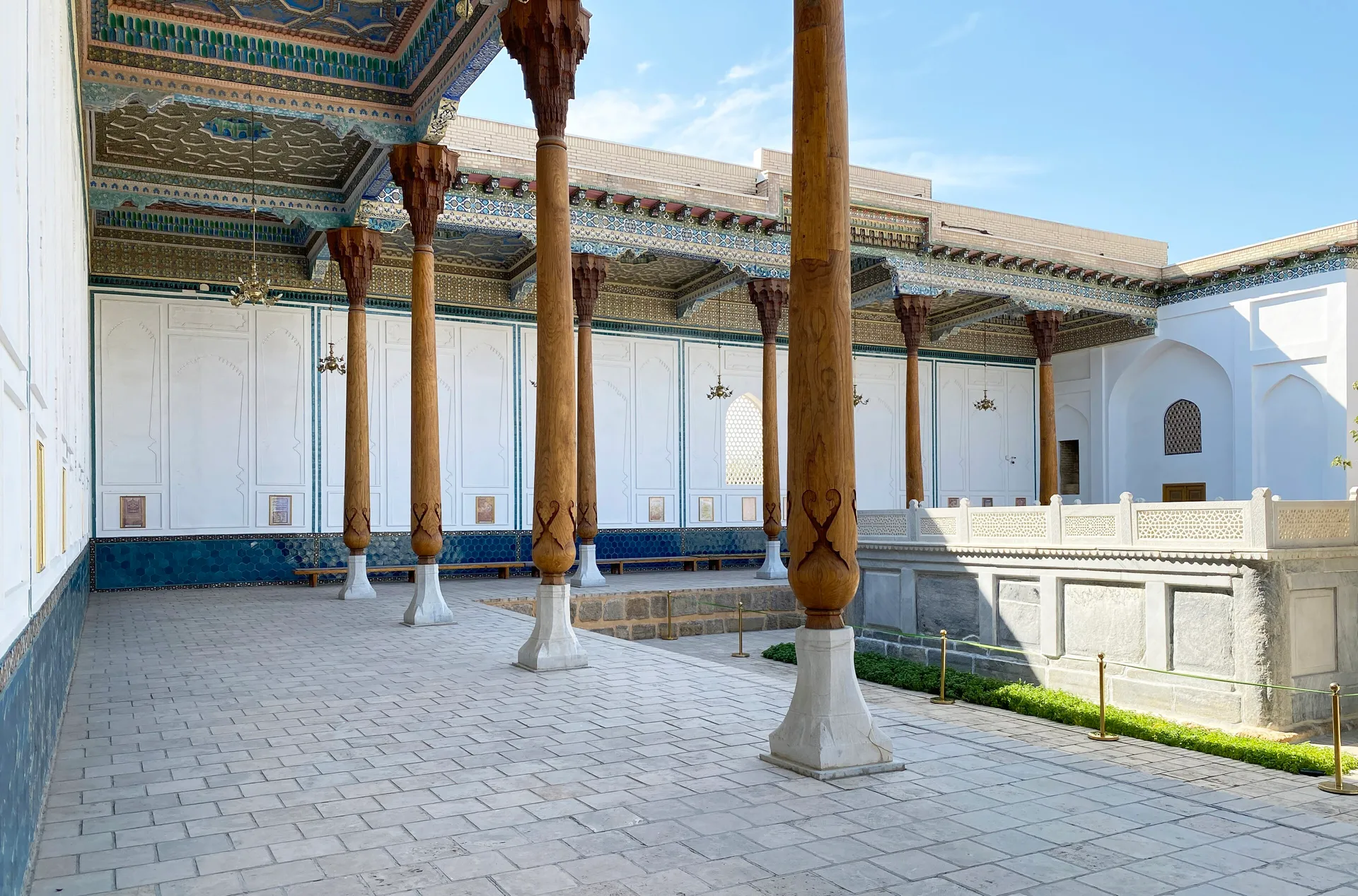 The tall wooden columns of an aivan, a shaded open-fronted hall, in the Bahouddin Naqshband complex.